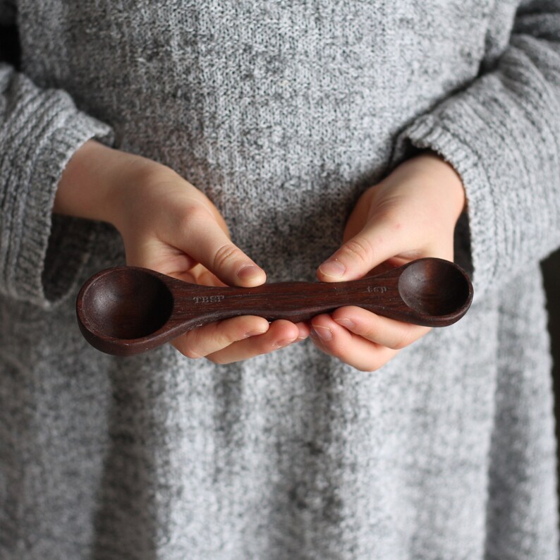 May include: A dark brown wooden measuring spoon with two sides, one marked "1 Tbsp" and the other marked "1/4 cup".