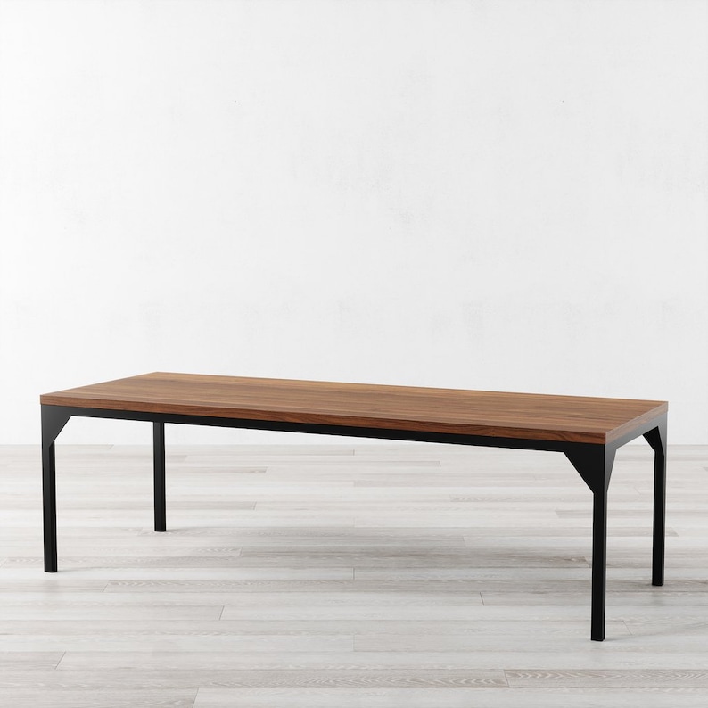 May include: A long, rectangular wooden table with a black metal frame. The table has a natural wood finish and a simple, modern design.