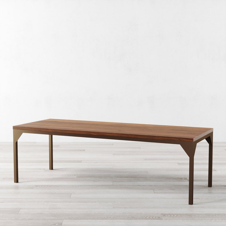May include: A long, rectangular wooden table with a brown wood top and a gold metal frame. The table has a simple, modern design and would be a great addition to any dining room or living room.