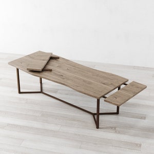 May include: A wooden dining table with a natural finish and a metal frame. The table has two leaves that can be extended to increase the table's length.