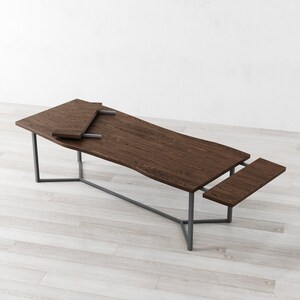 May include: A dark brown wooden dining table with a metal frame and two leaf extensions. The table is shown with the extensions pulled out, creating a longer table.