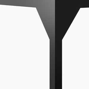 May include: Close-up of a black metal table leg with a unique Y-shaped design. The leg is made of a sturdy, durable material and features a smooth, matte finish.