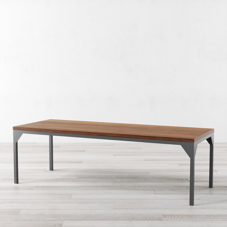 May include: A long, rectangular dining table with a dark wood top and a gray metal frame. The table has a simple, modern design.