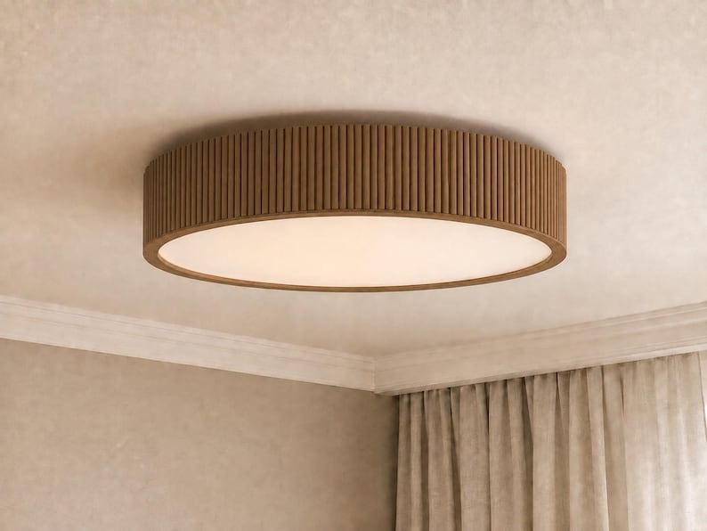 May include: A circular flush mount ceiling light fixture featuring a brown wooden exterior with a vertical slatted design and a flat, opaque white diffuser panel centered on the bottom, mounted directly against a light-colored ceiling surface.
