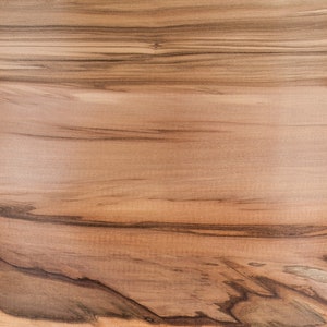 Puede incluir: Primer plano de un patr&oacute;n de veta de madera de color marr&oacute;n claro con vetas marr&oacute;n oscuro. La madera tiene un acabado liso y pulido.
