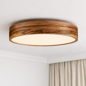 May include: A circular flush mount ceiling light fixture featuring a natural wood grain frame with a warm brown finish and a flat, opaque white diffuser panel that emits a soft, even glow across the surface of the light fixture.