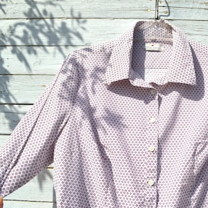 May include: White long-sleeve button-down shirt with a small, repeating geometric pattern in purple.
