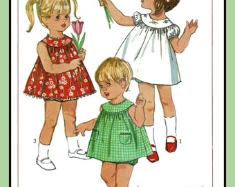 May include: A vintage Simplicity sewing pattern for toddler dresses. The pattern number is 6995 and the price is 50 cents. The pattern shows three different dresses, one red with white flowers, one white with a ruffled collar, and one green with white gingham. The pattern includes instructions for making the dresses.