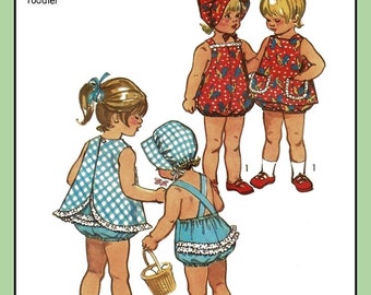 May include: A vintage Simplicity sewing pattern for toddler girls' dresses. The pattern includes three different styles: a blue and white gingham dress with a ruffled hem, a red and white floral dress with a ruffled hem, and a blue and white gingham dress with a ruffled hem and a white bib. The pattern is for size 1/2, with a 19-inch breast and waist.