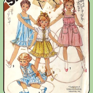 May include: A vintage illustration of children's dresses. Three girls are depicted wearing dresses in blue, yellow, and pink, each holding a hula hoop. The image includes text and the trademark of Cinderella Clothing Industries, Inc.