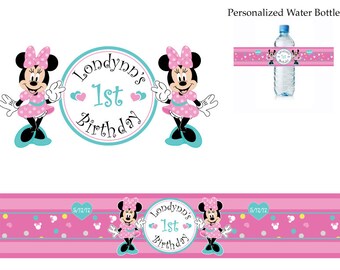 May include: Pink and black Minnie Mouse birthday party water bottle labels with a pink background and white polka dots. The labels feature a Minnie Mouse character with a pink dress and a bow. The text on the label reads "Londynn's 1st Birthday".