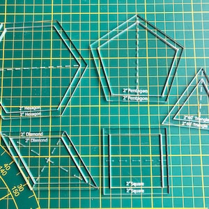 Op de afbeelding: Een set transparante plastic naai sjablonen voor het maken van verschillende vormen, waaronder een zeshoek, een ruit, een vijfhoek, een vierkant en een driehoek. De sjablonen zijn gelabeld met hun vorm en grootte in inches.