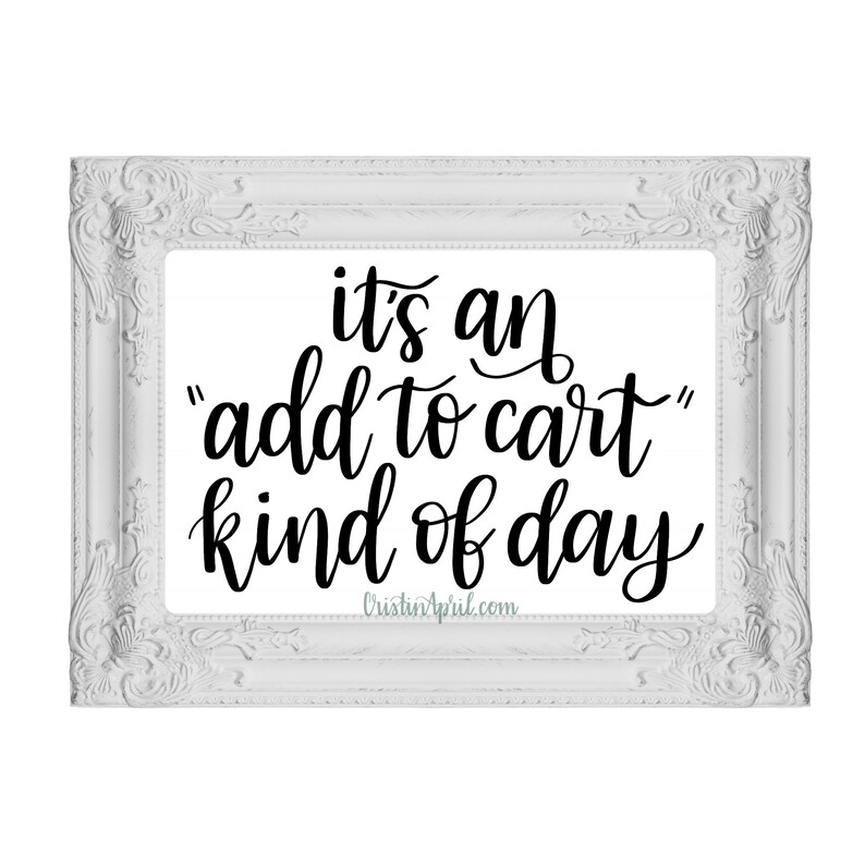 May include: White framed print with black text that reads "it's an "add to cart" kind of day" and the website address "CristinApril.com".