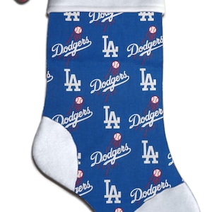 Könnte beinhalten: Ein blauer und weißer Weihnachtssocken mit einem weißen Bündchen, auf dem der Name "Brian" in Blau gestickt ist. Der Socken ist mit einem sich wiederholenden Muster des Logos der Los Angeles Dodgers verziert.