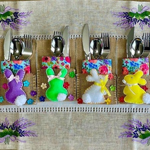 May include: Set of 10 Easter bunny-themed silverware holders. Each holder is made of burlap and features a felt bunny with a different color. The bunnies are holding a fork and spoon.