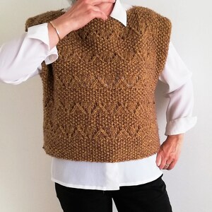 May include: A brown knitted sleeveless sweater vest with a diamond pattern.