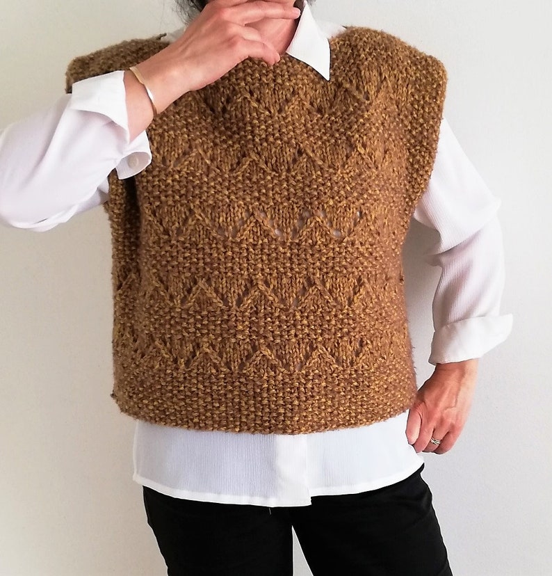 May include: A brown knitted sleeveless sweater vest with a diamond pattern.