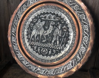 Cargador de cobre en relieve con decoración de camello