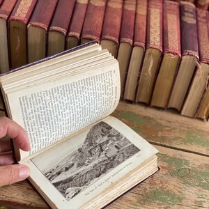 May include: An open book with a black and white photo of a mountain pass. The text on the page reads "The Pass of God is Great, looking down on Sivas."