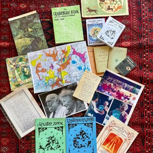 Może przedstawiać: Kolekcja książek, broszur i map z tytułami takimi jak The Glastonbury Zodiac, The Kingston Zodiac i The Book of Enoch. Przedmioty zawierają różne ilustracje, diagramy i fotografie, a niektóre strony zawierają odręczne notatki.