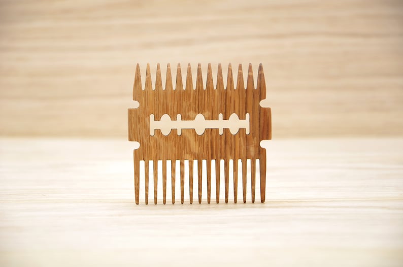 May include: A wooden comb with a razor blade design. The comb has a brown wood grain and is made of natural wood.