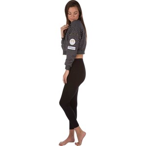 May include: A black and white patterned cropped sweatshirt with a gold logo that says "Moments". The sweatshirt is worn with black leggings.