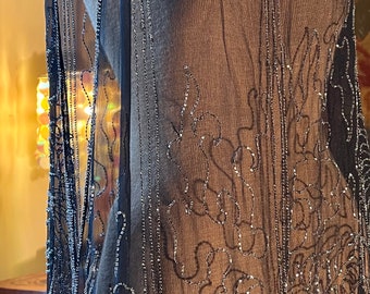May include: A black sheer beaded gown with silver beading in a floral pattern.