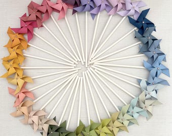 Mini spinning pinwheels in a gradient of colors with rose gold center brads