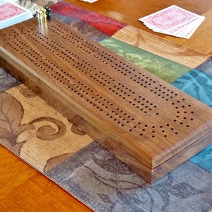 Walnut Cribbage board with 3 tracks and storage for pegs and cards