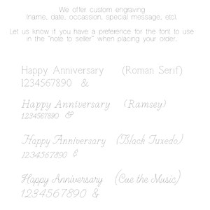 Image shows four examples of custom engraving text styles.  Each example displays the words 'Happy Anniversary',  numbers '1234567890', and an ampersand, followed by the name of the font. The fonts shown are Roman Serif, Ramsey, Black Tuxedo, and Cue the Music.  The image also directs the customer to specify font preference when ordering.