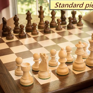 Walnut and maple chess board with standard wooden chess pieces set up to play.