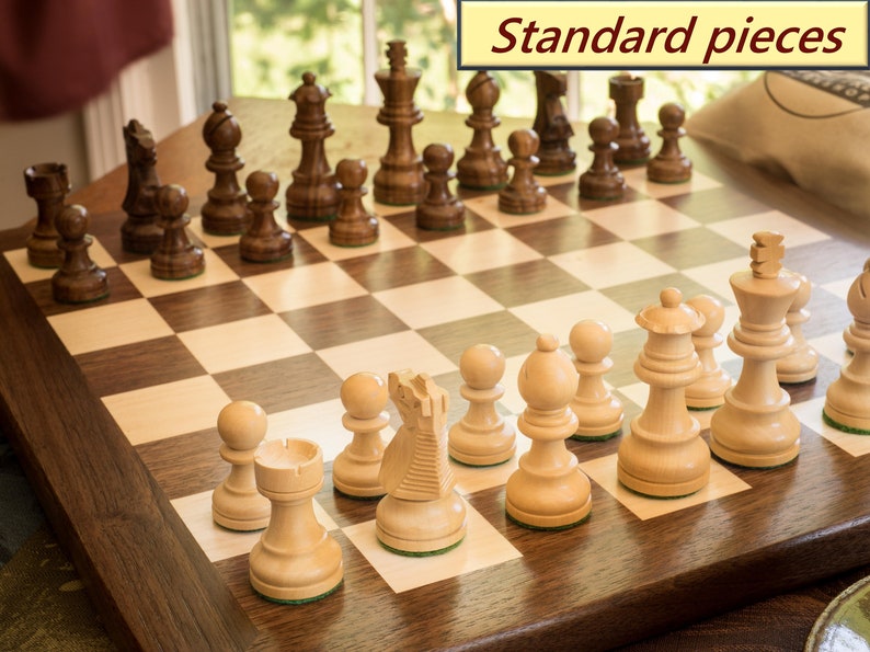 Walnut and maple chess board with standard wooden chess pieces set up to play.