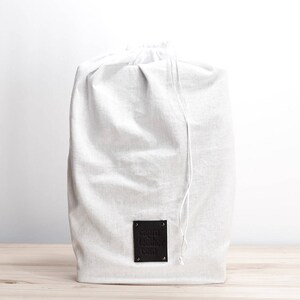May include: A white linen drawstring bag with a black leather label that says "Sayuri Leather Co."