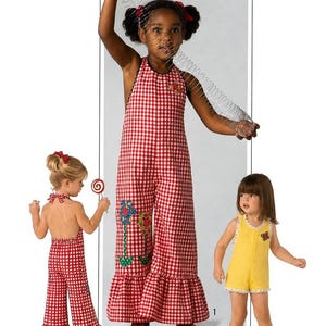 May include: A sewing pattern envelope labeled S7557 for a child size 6 garment. It features a red and white gingham jumpsuit with a ruffled hem and floral appliqués, and a yellow romper with white lace trim. Pattern pieces for appliqué are included.
