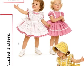 May include: A printed pattern for children's clothing, labeled S1896, size 6 Month. The image displays four outfits: a pink and white dress with an apron, a solid pink dress, a yellow floral dress with a matching bonnet, and a white dress with blue bows.
