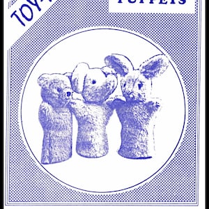 以下が含まれることがあります： ヴィンテージの手袋人形のパターン。画像には、クマ、ウサギ、別のウサギの3つのぬいぐるみ人形が写っています。「TIP-TOP TOY-PATTERNS」と「GLOVE PUPPETS」というテキストがあります。デザインは青と白です。