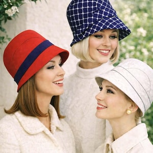 May include: Three women wearing vintage-style hats. One hat is red with a blue band, another is navy blue with a white grid pattern, and the third is white with horizontal lines. The women are smiling.