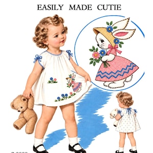 Op de afbeelding: Een naaipatroon getiteld PATTERN No. R2089 EASILY MADE CUTIE met een witte jurk met blauwe afwerking en geborduurde konijn- en bloemmotieven. Het patroon toont een kind in de jurk, een gedetailleerde illustratie van het konijnontwerp en een achteraanzicht van de jurk met blauwe stippen.