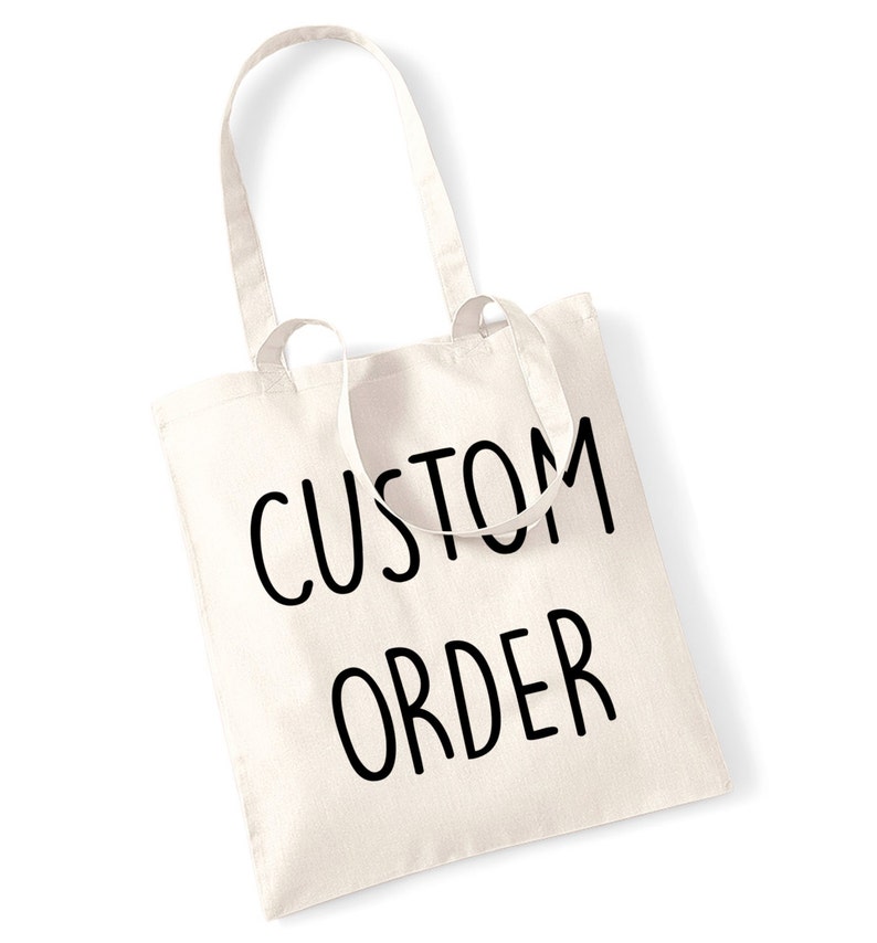 May include: Cream-colored tote bag with the words "CUSTOM ORDER" printed in black. The bag has two long handles and is made of a sturdy fabric. The bag is designed for carrying items and is suitable for various uses.