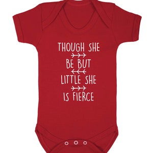 May include: A red baby bodysuit with white text that reads "THOUGH SHE BE BUT LITTLE SHE IS FIERCE". The bodysuit has short sleeves and poppers at the bottom. The text is in a simple, easy-to-read font.
