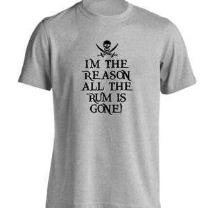 May include: A light grey t-shirt with a crew neck. The shirt displays a black graphic of a skull and crossed swords above the text "I'M THE REASON ALL THE RUM IS GONE!". The design has a pirate theme.