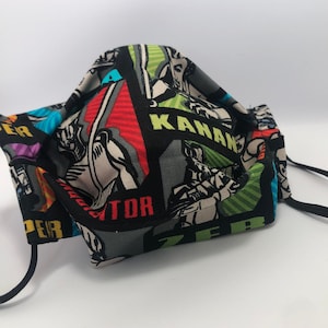 May include: Black face mask with a colorful print featuring characters from the Star Wars franchise. The print includes the names "Kanan", "Zeb", "Hera", and "Ezra".