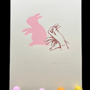 May include: A pink rabbit shadow puppet is being made with a hand. The hand is labeled "LEFT". The print is signed "Sarah Jane Welch" and numbered "23/30". The text "RABBIT!" is also included.