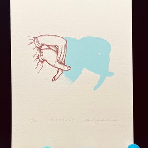 May include: A hand-drawn illustration of a hand making an elephant shadow puppet. The image is printed on cream-colored paper with a light blue elephant shadow. The print is numbered 14/30 and signed "Sarah Joncas".