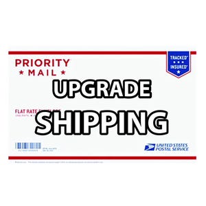 May include: A white Priority Mail shipping label with red and blue accents. The label says "PRIORITY *MAIL*" and "UPGRADE SHIPPING". The label also has a "TRACKED INSURED" sticker with a blue star.