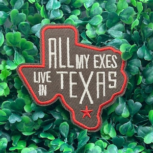 Peut inclure: Un écusson marron en forme du Texas avec une bordure rouge. Le patch porte l'inscription "ALL MY EXES LIVE IN TEXAS" en lettres blanches, avec une étoile rouge en bas.