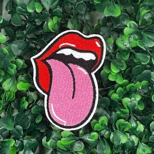 May include: Red and pink embroidered iron-on patch of a tongue sticking out of a mouth.