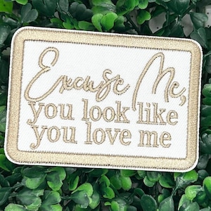 Op de afbeelding: Witte geborduurde patch met een gouden rand. De patch zegt "Excuseer me, je ziet eruit alsof je van me houdt."