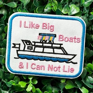 May include: White embroidered patch with a blue border. The patch features a cartoon boat with a pink awning and the text "I Like Big Boats & I Can Not Lie" in pink.