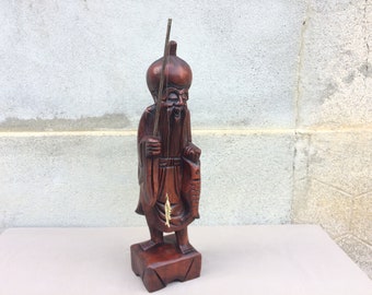 木製の台に置かれたヴィンテージの中国漁師の樹脂製置物、ボートで釣り